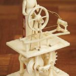 EARLY 19TH CENTURY CARVED MECHANICAL MINIATURE BONNETED LADY AT HER SPINNING WHEEL